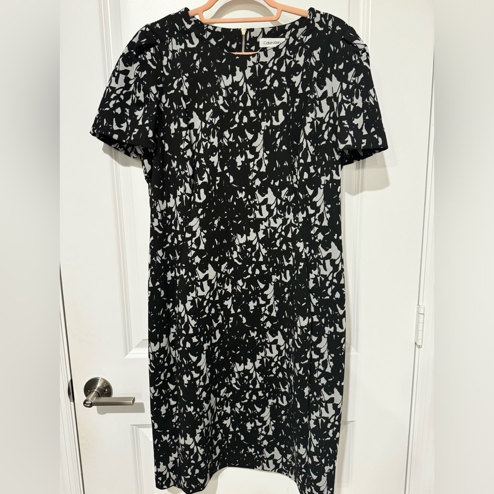 Calvin Klein black and white sheath dress with gold zipper detail.